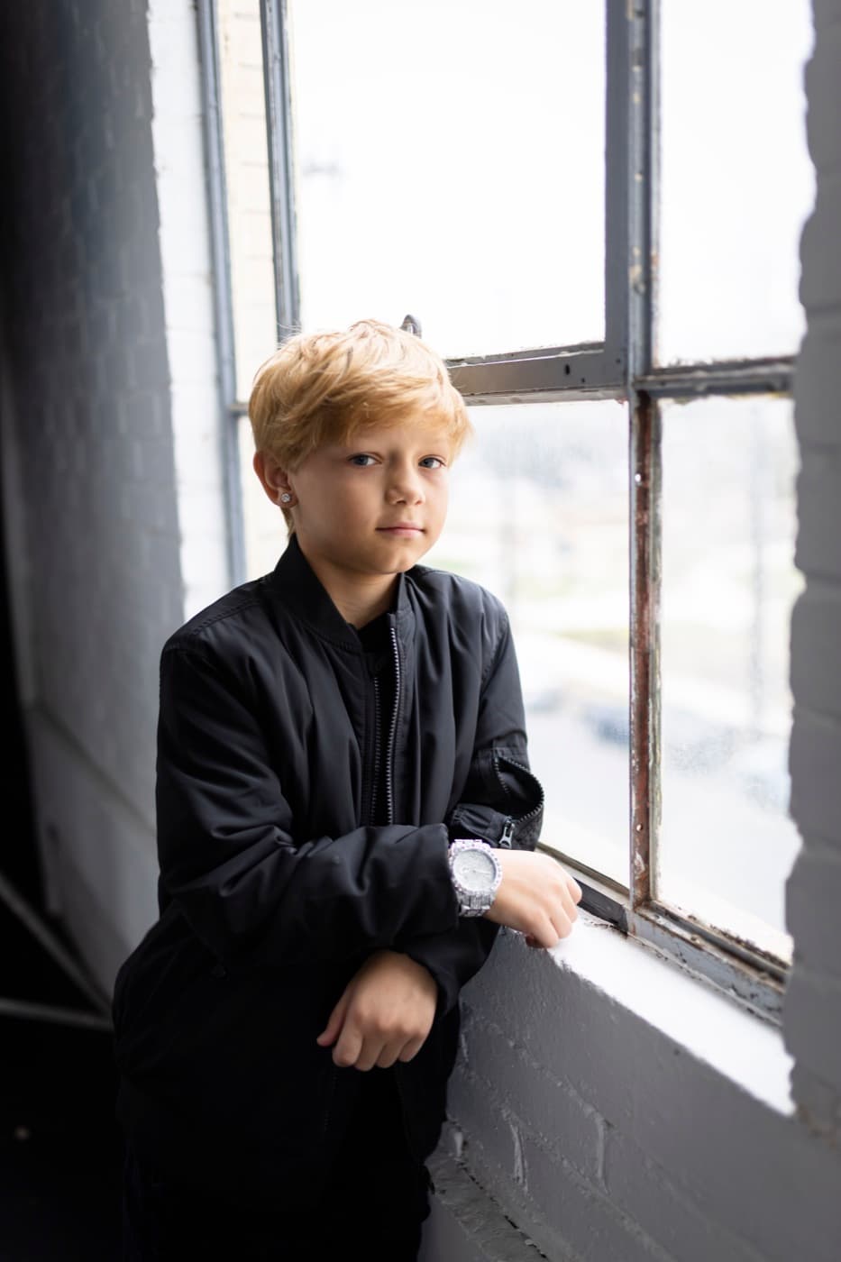 Luca leaning against a window sill